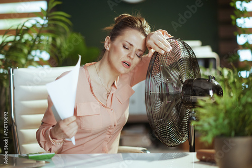 modern woman employee at work suffering from summer heat