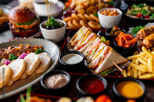 A delightful spread of food: sandwiches, sushi, and a burger, all beautifully presented. Perfect for a feast