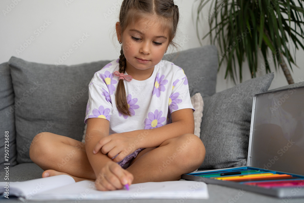 Adorable little girl draws in living room at home Adorable little girl draws in living room at home