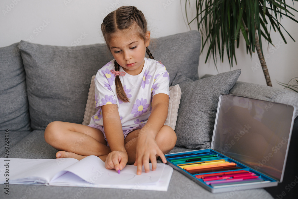 Adorable little girl draws in living room at home Adorable little girl draws in living room at home