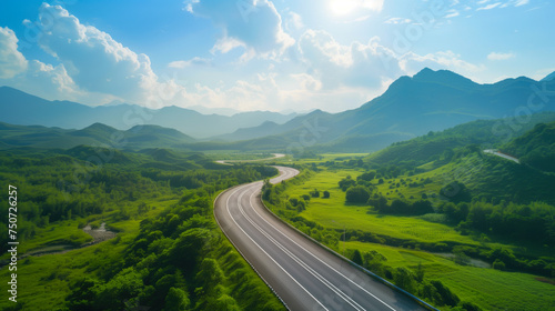 Serene Aerial View of Winding Highway Through Lush Green Mountains and Valleys.