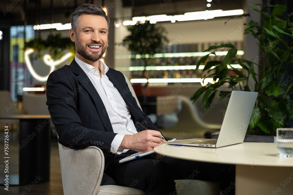 Smiling elegant businessman working and looking contented