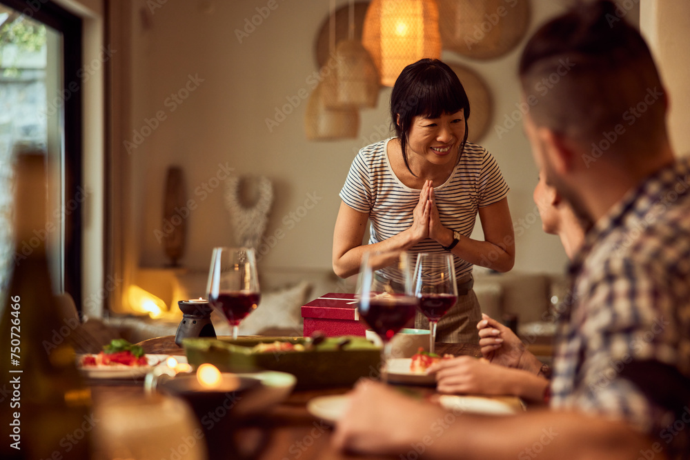 An Asian female friend feels thankful for the gifts from her friends, during the birthday dinner.