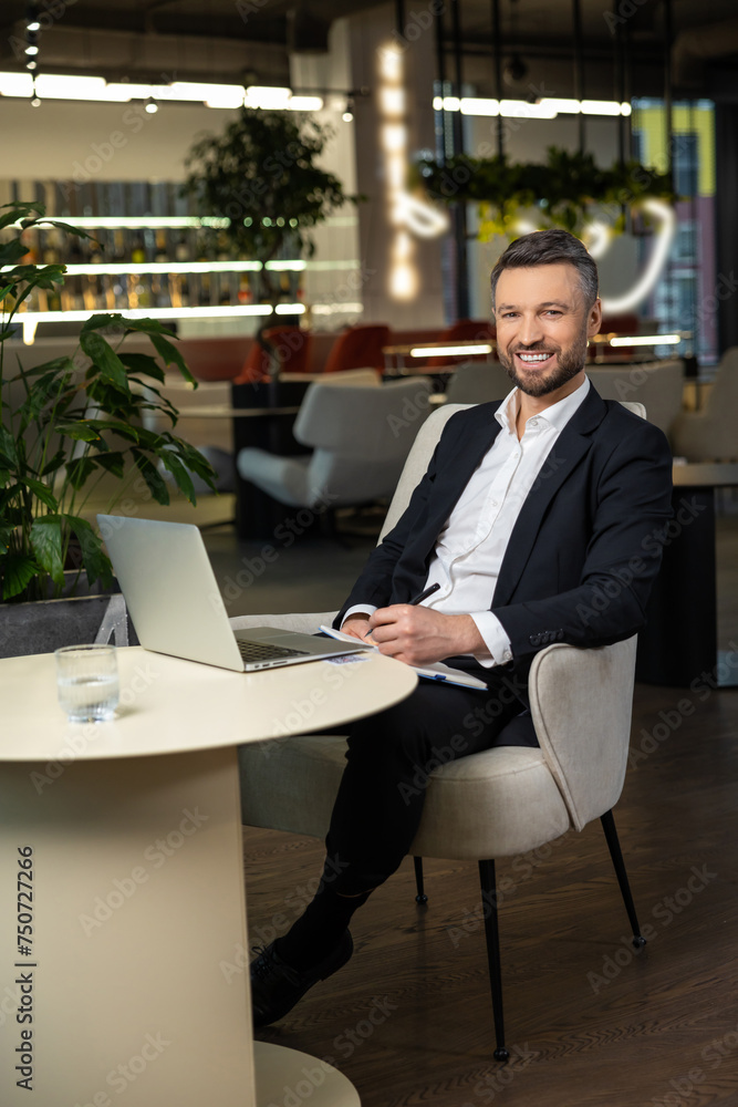 Smiling elegant businessman working and looking contented Smiling elegant businessman working and looking contented