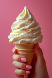 Female hand with pink manicure holding ice cream cone on pink background