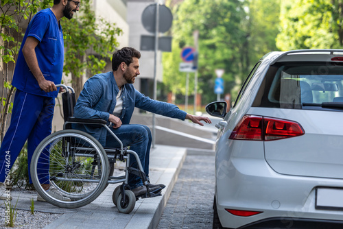 Man on a wheelchair getting into a car © zinkevych