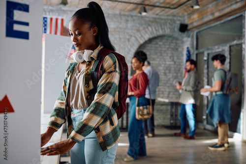 Bild auf Leinwand Young black woman at voting booth during United States of America elections