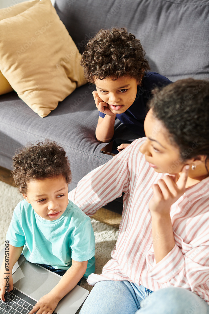 good looking african american mother having great time with her adorable little sons in living room good looking african american mother having great time with her adorable little sons in living room