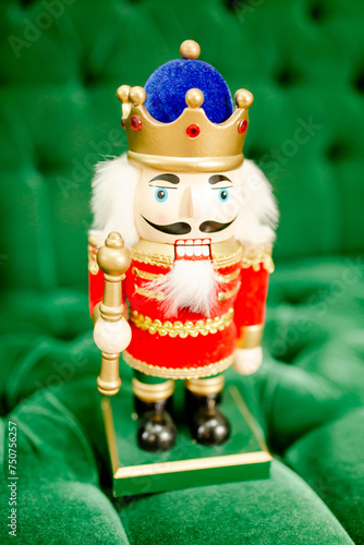 Nutcracker doll on green velvet couch.