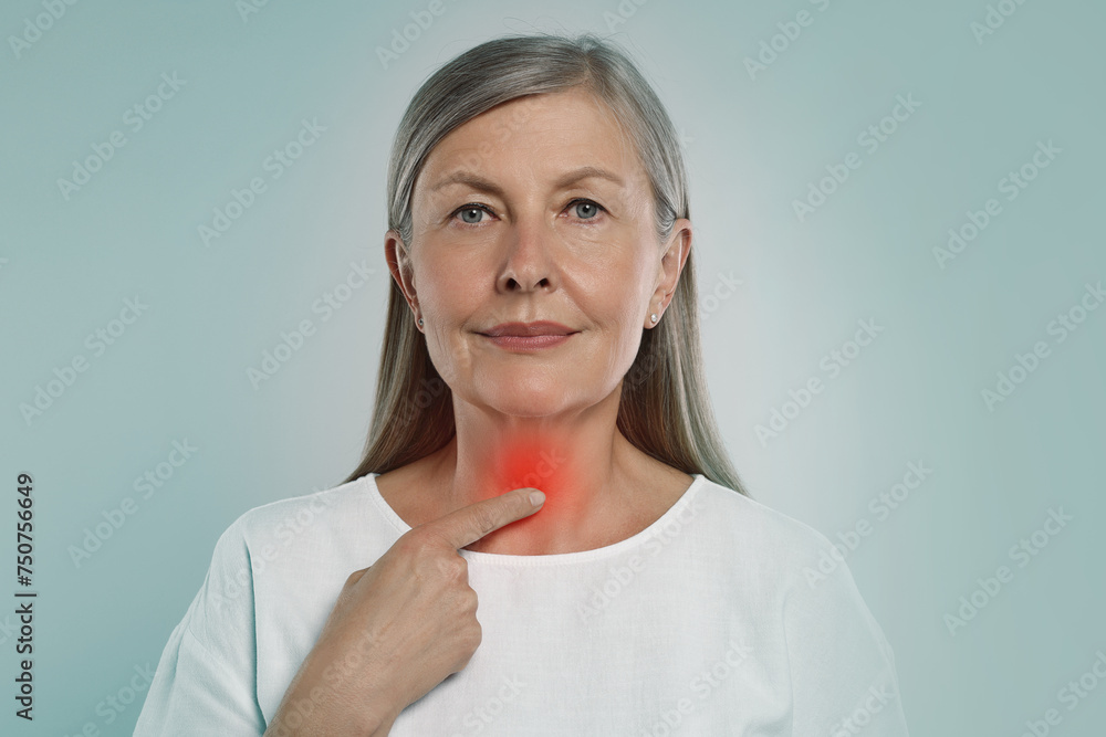 Endocrine system. Woman doing thyroid self examination on light blue background Endocrine system. Woman doing thyroid self examination on light blue background