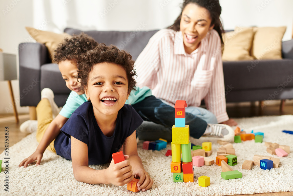 focus on jolly african american boy smiling at camera with his blurred mom and brother on backdrop focus on jolly african american boy smiling at camera with his blurred mom and brother on backdrop