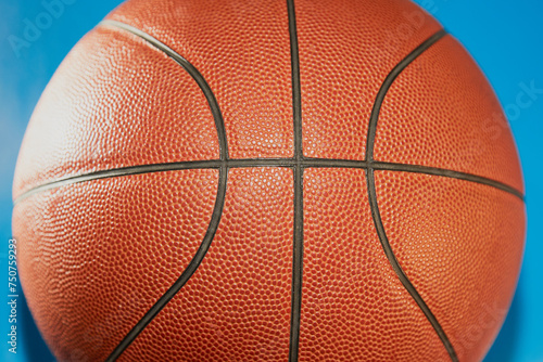 Orange basketball on a light blue background close-up, sports background, poster for a sports basketball match. © Александр Ланевский