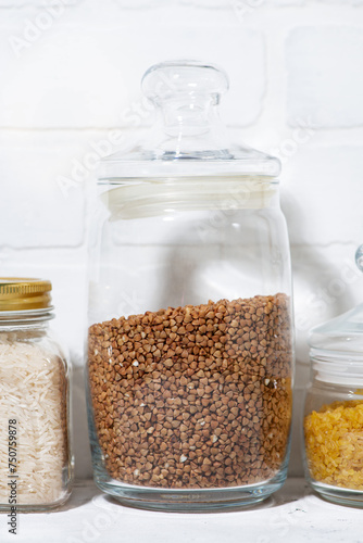 cereals in glass jars on a white background, vertical closeup