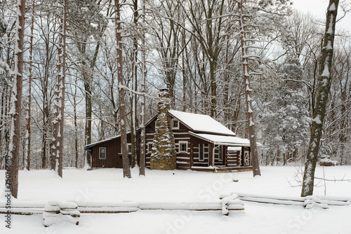 A cabin along the road in Brown County State Park. The ground and trees are covered in snow in the middle of winter in Indiana. 