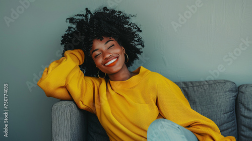 Relaxed Woman Enjoying a Quiet Moment on a Grey Couch © swissa