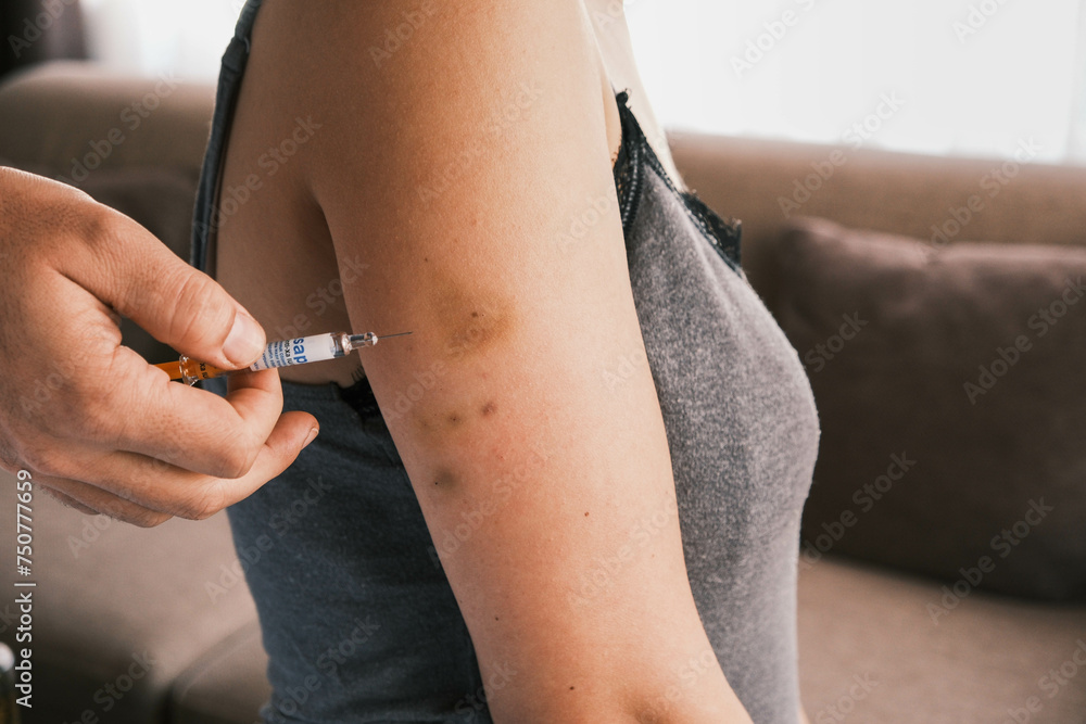 Closeup of giving an intramuscular anticoagulant injection into the arm