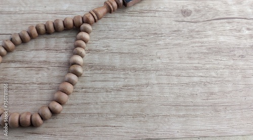 wooden rosary on a wooden background with space for text