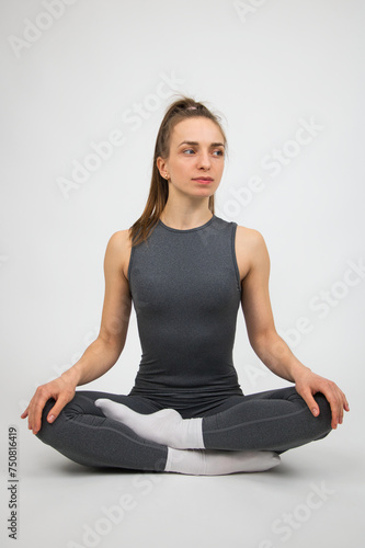 Young beautiful woman doing stretching exercise on white background. Studio shot