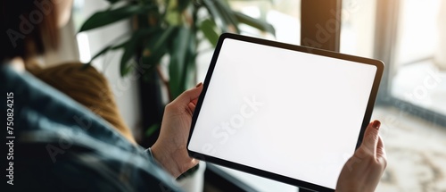 A person holding a tablet with a blank screen suitable for digital design mockups, business presentations, or technological demonstrations. photo