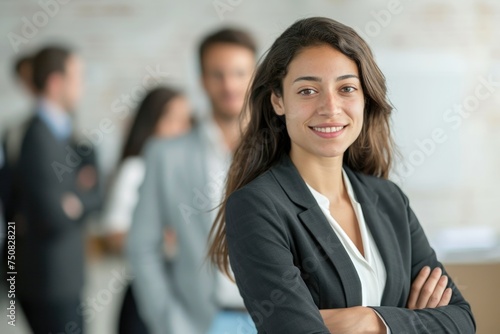 A confident woman standing in front of a diverse group of people, exuding leadership and authority