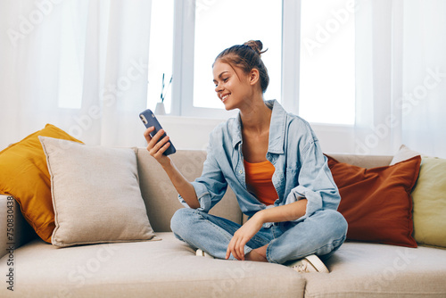 Happy Woman Relaxing on Sofa, Holding Mobile Phone and Smiling, Enjoying Online Gaming and Reading, Taking Selfie, Chatting in Cyberspace