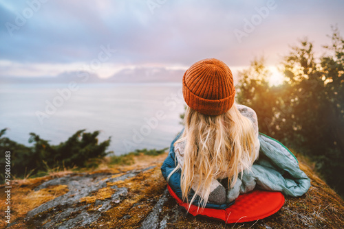 Woman relaxing outdoor bivouac with camping gear summer vacations girl hiking solo enjoying sea view active tourism tourist exploring Norway adventure healthy lifestyle trip sustainable tourism