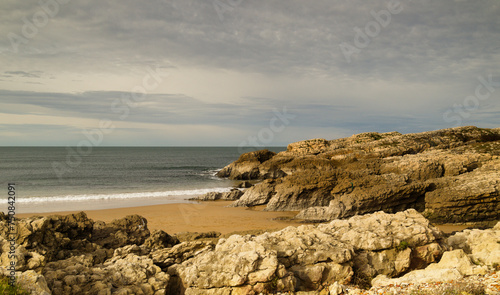 Cantabria, small wave-cut beach Playa del Bocal, light sand and eroded rock cliffs 