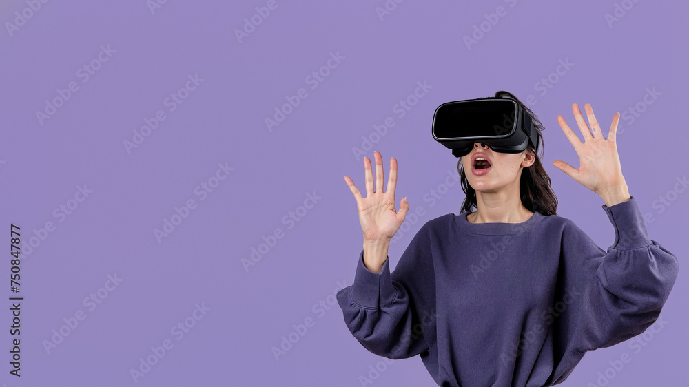 A woman with raised hands seems to be thoroughly enjoying the advanced virtual reality technology in front of her