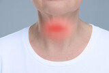 Endocrine system. Woman suffering from pain in thyroid gland on grey background, closeup