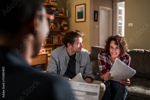 Couple talking about financials to advisor at home photo