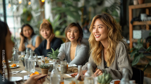 Group of asian women enjoying a meal together at restaurant, looking each other