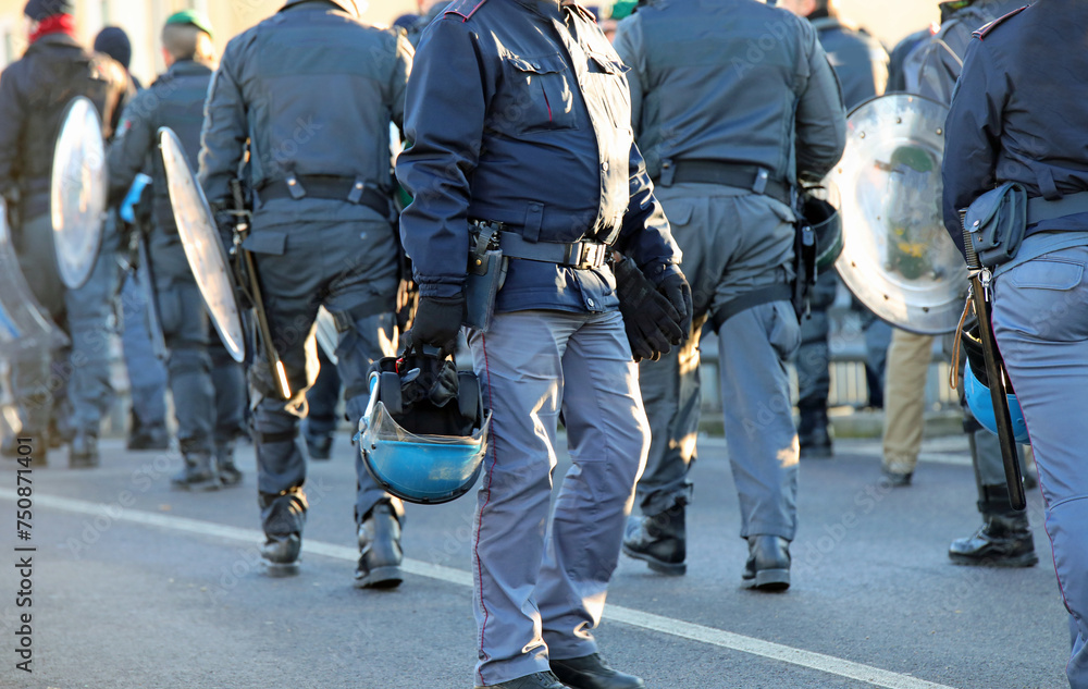 policemen in riot gear with protective helmet and truncheons during the protest demonstration policemen in riot gear with protective helmet and truncheons during the protest demonstration