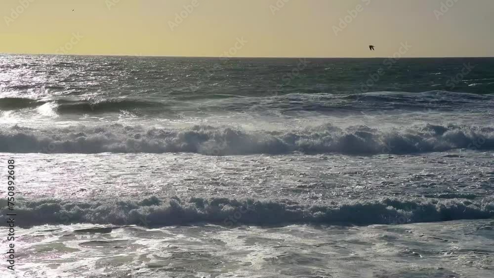 Rough sea under an orange sky at sunset Rough sea under an orange sky at sunset