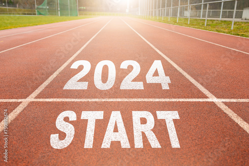 Happy New Year 2024 symbolizes the start of the new year. Rear view of a man preparing to run on the athletics track engraved with the year 2024. The goal of Success.Getting ready for the new year.