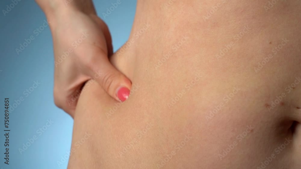 Woman in close-up shows fat measurement. Fat belly. Medium size. Fat indicator on a blue background. High quality 4k footage. Woman in close-up shows fat measurement. Fat belly. Medium size. Fat indicator on a blue background. High quality 4k footage.