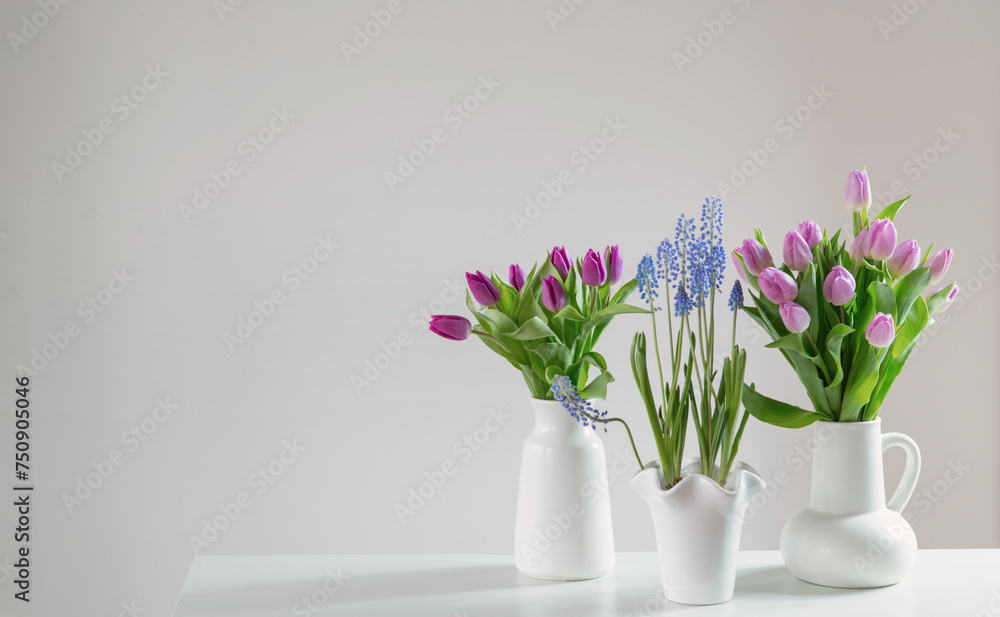 spring flowers in white vases in white interior spring flowers in white vases in white interior
