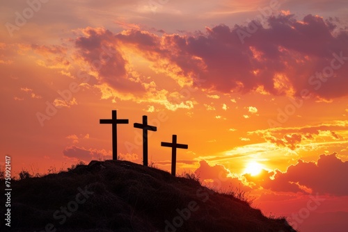 Three crosses on a hill with dramatic sunset in the background