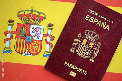 Red Spanish passport of European Union on national flag background close up. Tourism and citizenship concept photo