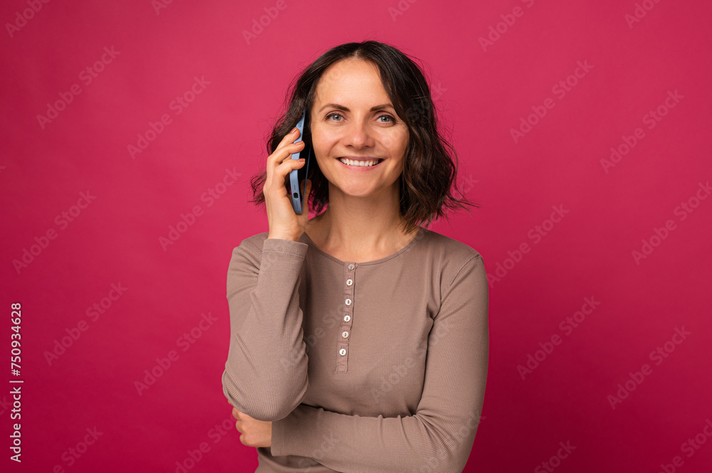 Handsome smiling middle age woman is having a pleasant conversation on the phone. Handsome smiling middle age woman is having a pleasant conversation on the phone.
