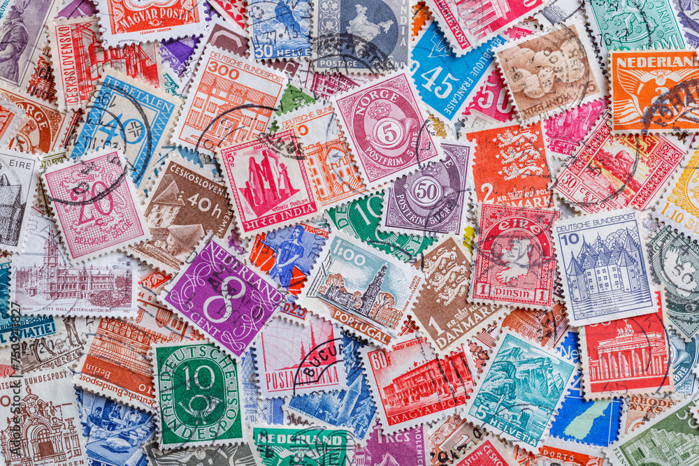 Ukraine, Kiyiv - January 12, 2023.Postage stamps.Collection of stamps and magnifying glass.A collection of world stamps in a pile.Postage stamps from different countries and times