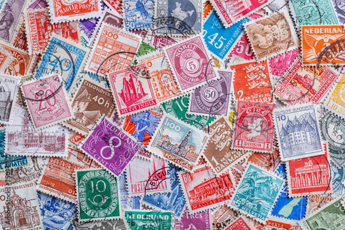 Ukraine, Kiyiv - January 12, 2023.Postage stamps.Collection of stamps and magnifying glass.A collection of world stamps in a pile.Postage stamps from different countries and times photo
