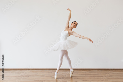 Woman in tutu motion, balance flexibility concept, lifestyle. Beautiful young female ballet dancer bending over effortless on stage with harmony, body shape movement, fitness flexibility indoors. .