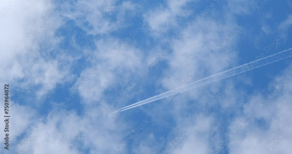 Airplane flying on deep cloudy blue sky with chemical direction trails, view from a distance Airplane flying on deep cloudy blue sky with chemical direction trails, view from a distance