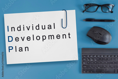IDP - Individual Development Plan. Business Acronym text on white paper on blurred desktop background. Concept for startup, small business, entrepreneurship, innovation.