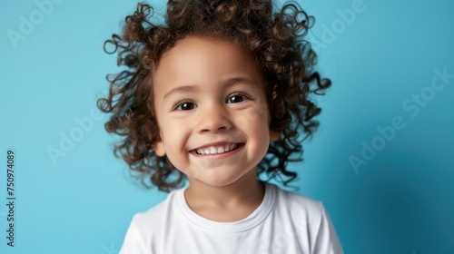 A cheerful little girl with curly hair smiling at the camera. Suitable for various concepts