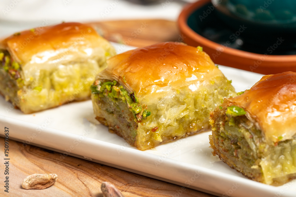 Pistachio baklava with turkish coffee on rustic table, ramadan or holiday desserts concept. Middle Eastern cuisine flavors. Close up Pistachio baklava with turkish coffee on rustic table, ramadan or holiday desserts concept. Middle Eastern cuisine flavors. Close up