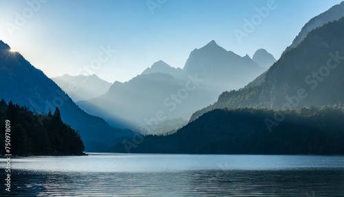 layers of mountains by the still lake in the morning