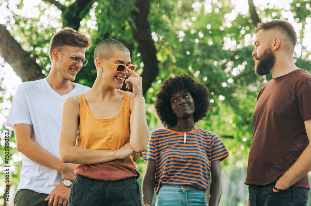 Interracial friends spending time together in city park. Interracial friends spending time together in city park.