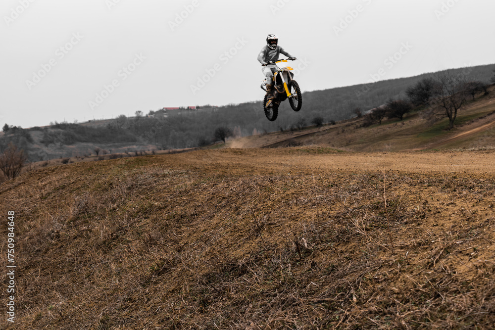 Person jumps on motocross bike with helmet into the sky Person jumps on motocross bike with helmet into the sky
