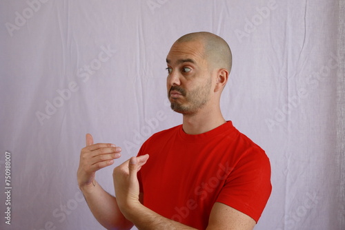 casual bald man in red shirt making hand gestures